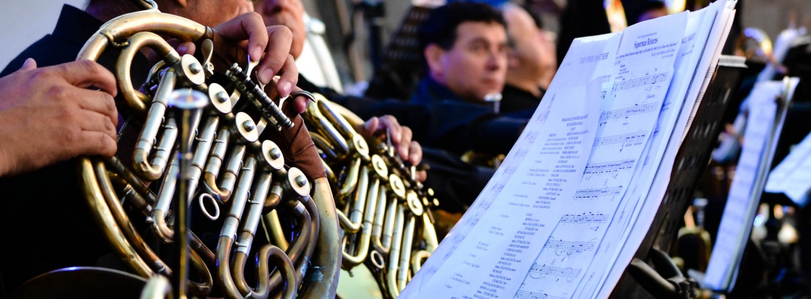 People playing french horns with sheet music